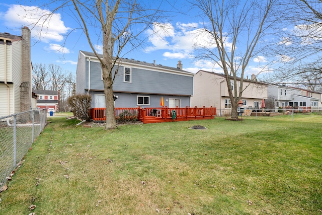 rear view of property with a yard and a wooden deck