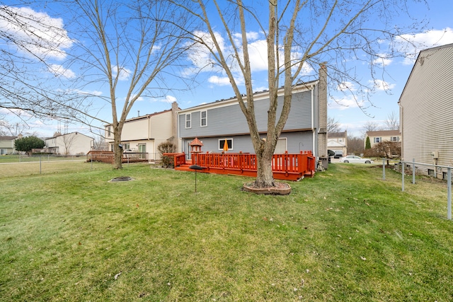 rear view of house featuring a wooden deck and a yard