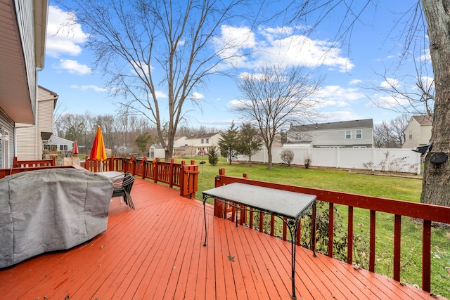 wooden terrace featuring grilling area and a lawn