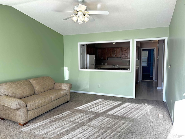 unfurnished living room with carpet, ceiling fan, lofted ceiling, and sink