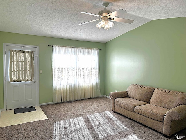 living room featuring a textured ceiling, ceiling fan, lofted ceiling, and carpet floors