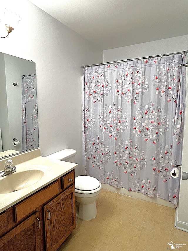 bathroom featuring vanity, toilet, and curtained shower