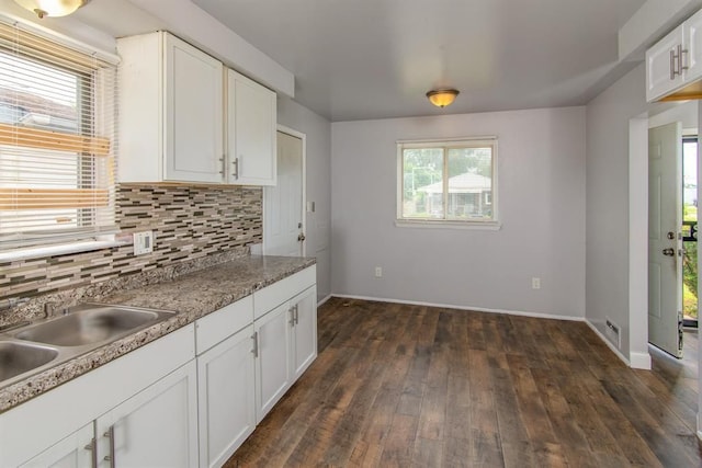 kitchen featuring light stone countertops, dark hardwood / wood-style flooring, tasteful backsplash, sink, and white cabinets