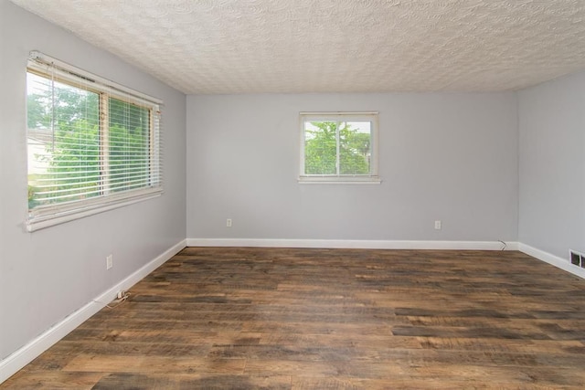 unfurnished room featuring dark hardwood / wood-style flooring and a textured ceiling