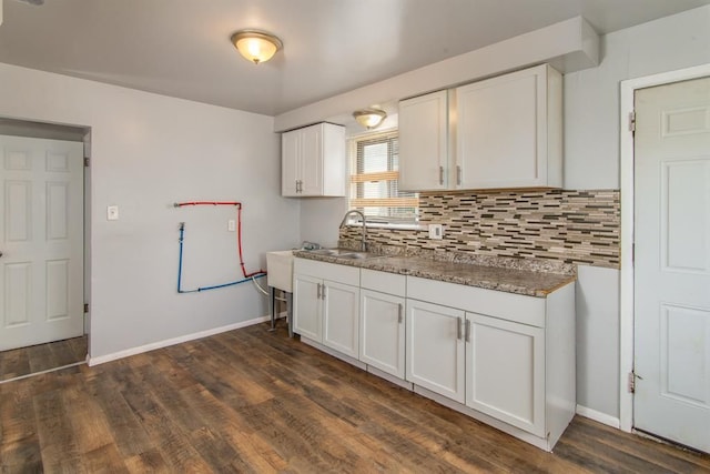 kitchen featuring backsplash, sink, white cabinets, and dark wood-type flooring