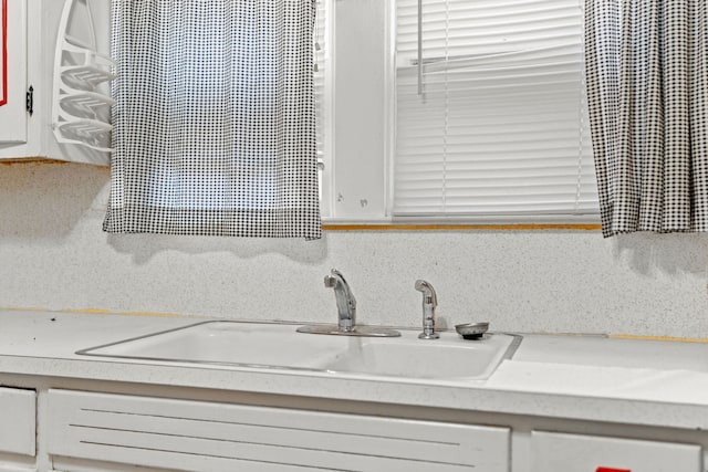 kitchen featuring white cabinets, tasteful backsplash, and sink