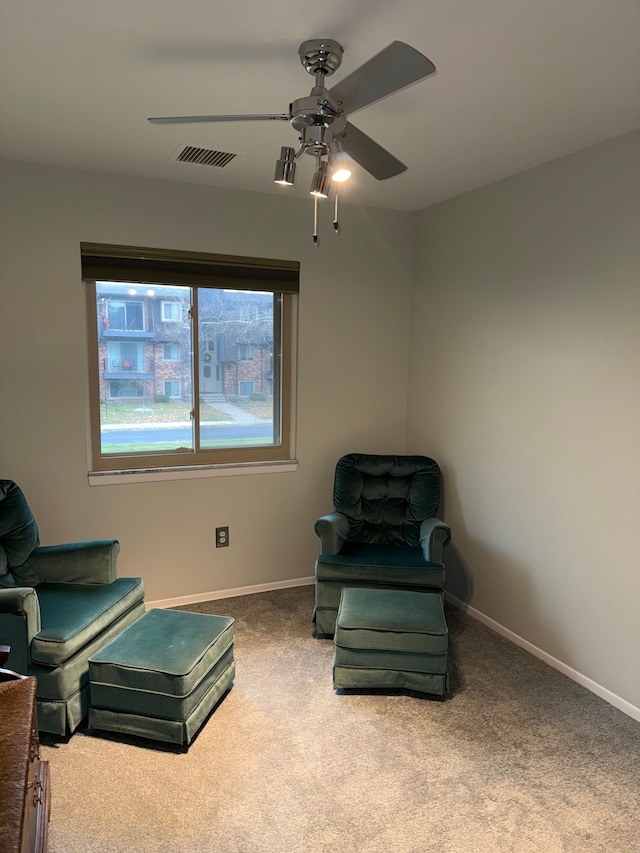 living area with carpet and ceiling fan