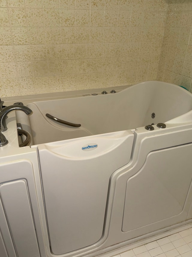 bathroom with a tub to relax in and tile patterned flooring