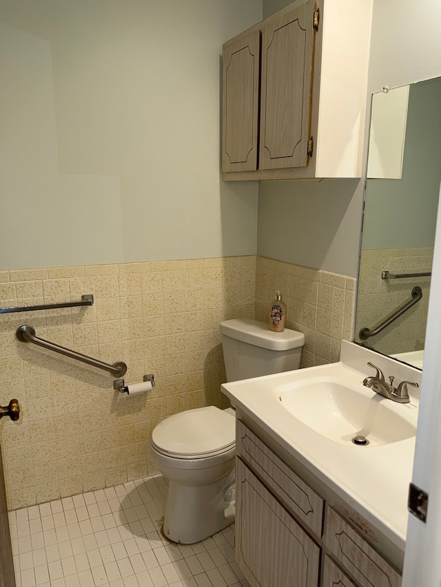 bathroom featuring tile patterned flooring, vanity, tile walls, and toilet