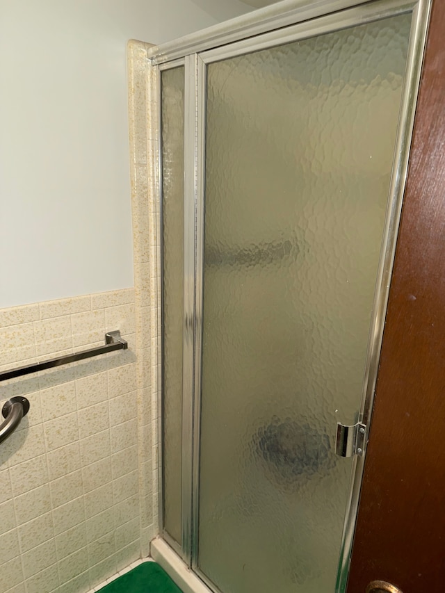 bathroom featuring tile walls and an enclosed shower