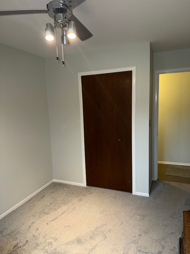 unfurnished bedroom featuring ceiling fan, carpet floors, and a closet