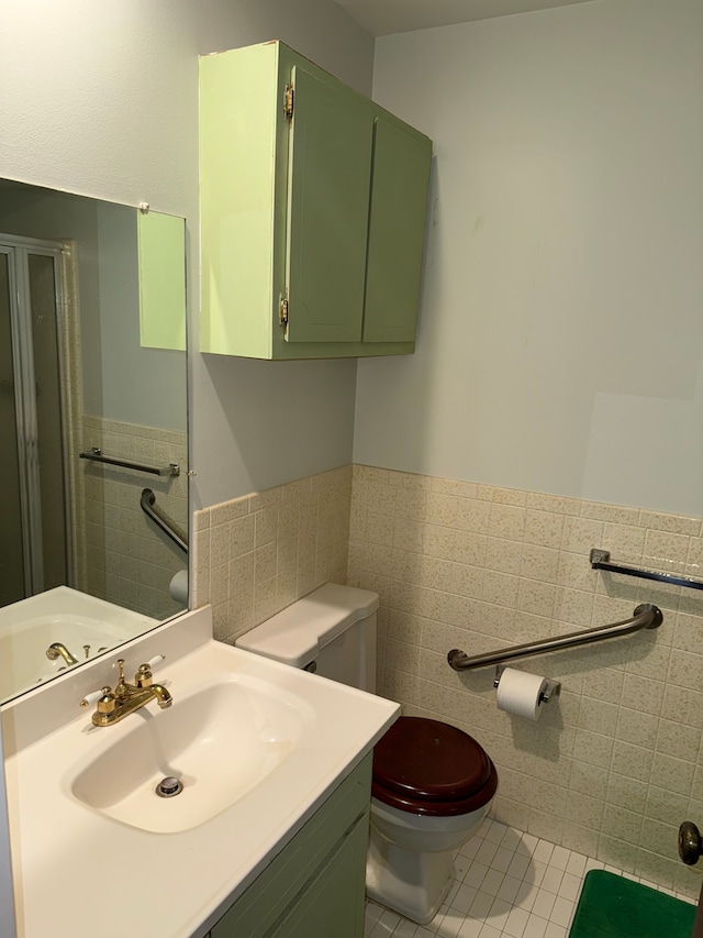 bathroom with tile patterned floors, vanity, tile walls, and toilet