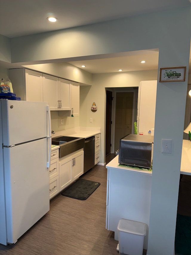 kitchen with dishwasher, white refrigerator, white cabinets, and sink