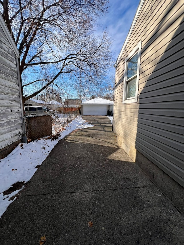 yard covered in snow featuring a garage and an outdoor structure