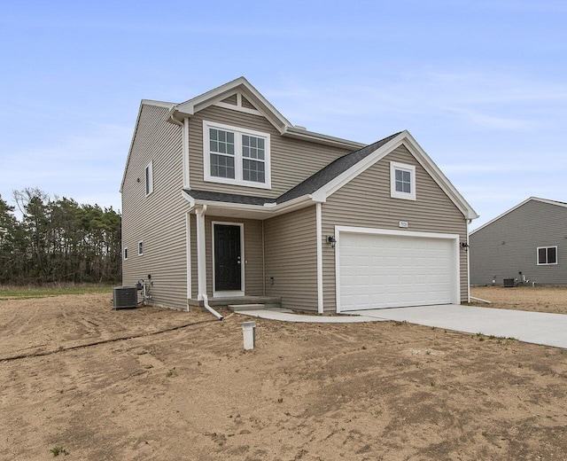 view of front of property with concrete driveway and central air condition unit