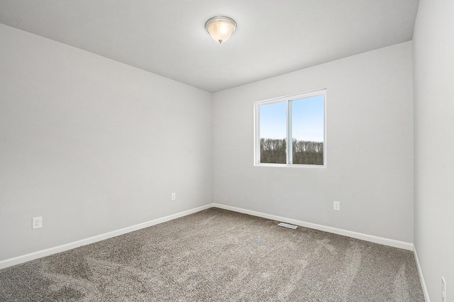 carpeted empty room featuring baseboards and visible vents