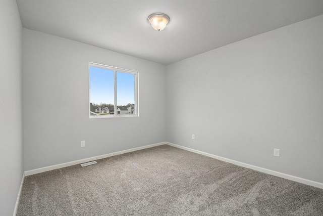 carpeted spare room featuring baseboards and visible vents