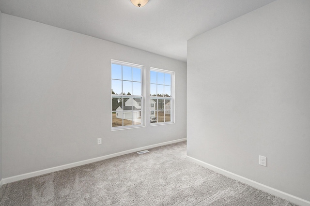 carpeted empty room featuring visible vents and baseboards
