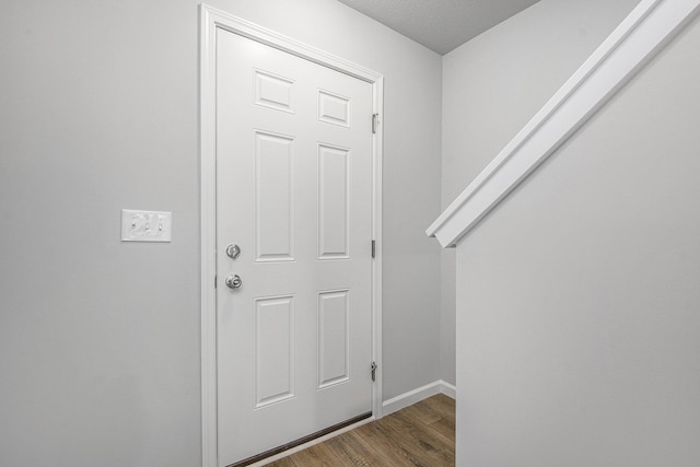 entryway featuring baseboards and wood finished floors