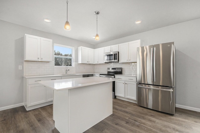 kitchen featuring dark wood-style floors, white cabinets, stainless steel appliances, and light countertops