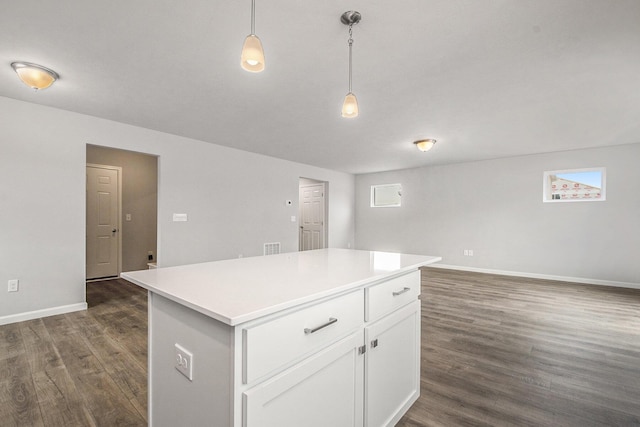 kitchen with a kitchen island, light countertops, white cabinets, baseboards, and dark wood-type flooring