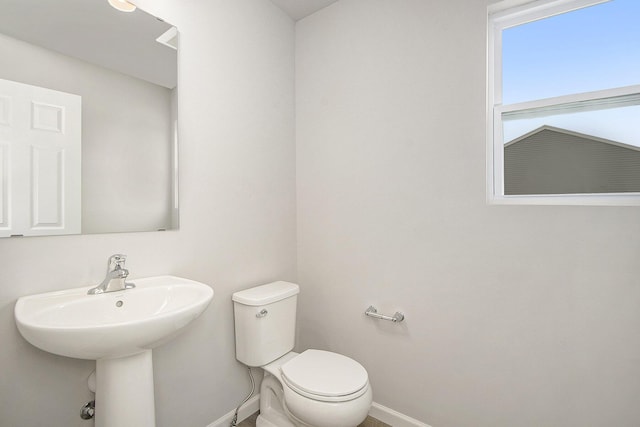 half bathroom with toilet and baseboards