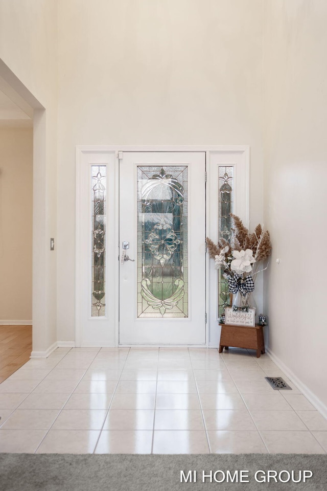 tiled foyer featuring a high ceiling