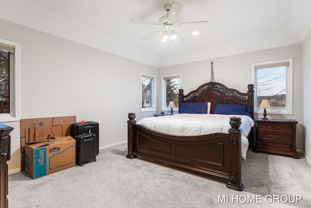 bedroom with multiple windows, ceiling fan, and light colored carpet