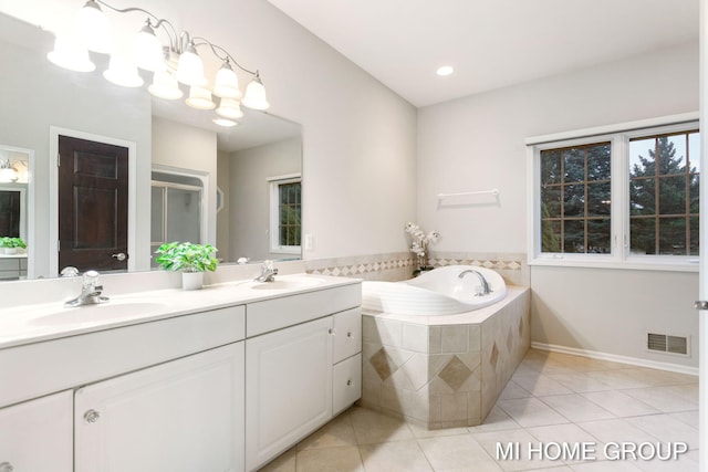 bathroom with tile patterned floors, vanity, and shower with separate bathtub