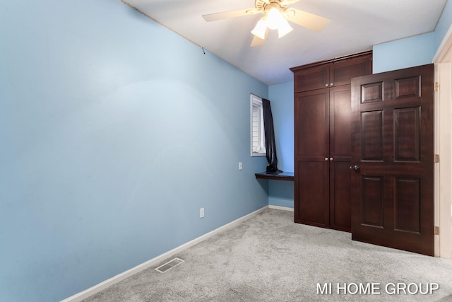 unfurnished bedroom with ceiling fan and light carpet