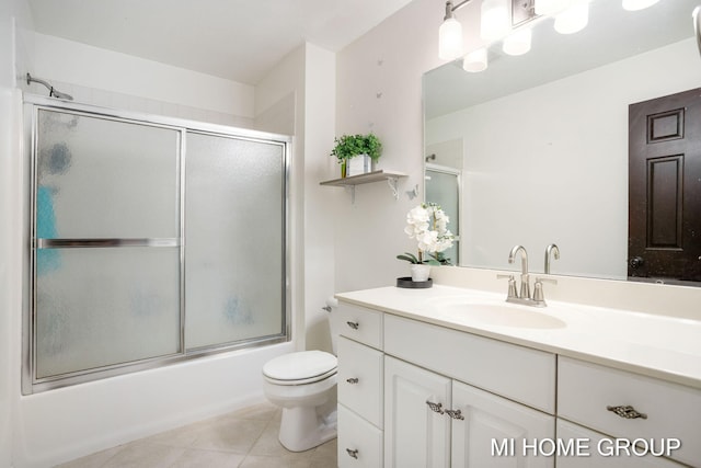 full bathroom with tile patterned flooring, vanity, toilet, and enclosed tub / shower combo