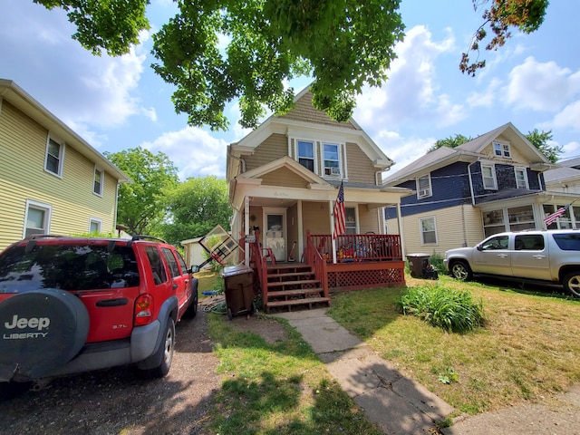 view of front of house with covered porch and a front lawn