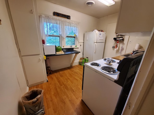 kitchen with white appliances, sink, and light hardwood / wood-style flooring