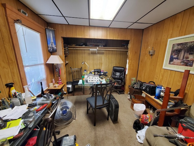 home office with carpet flooring, a drop ceiling, and wooden walls