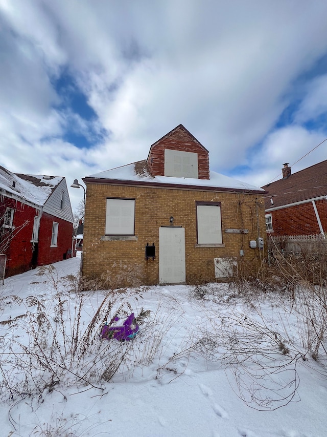 view of snow covered rear of property