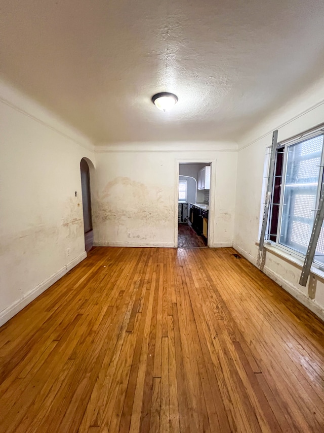 spare room with hardwood / wood-style flooring and a textured ceiling