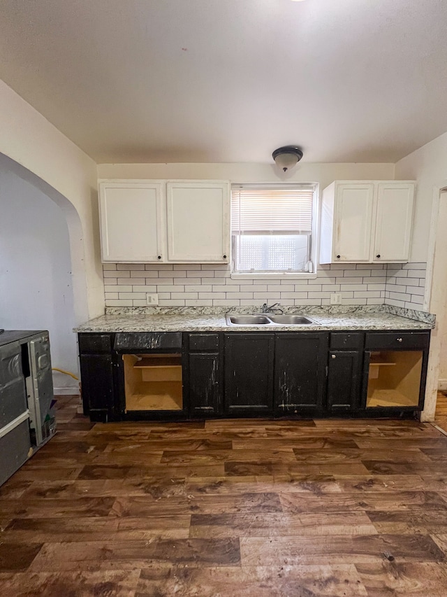 kitchen featuring tasteful backsplash, white cabinetry, dark wood-type flooring, and sink