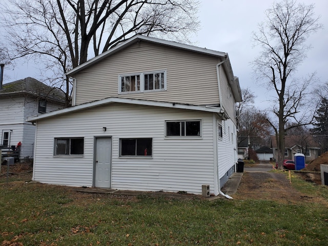 rear view of property featuring a lawn