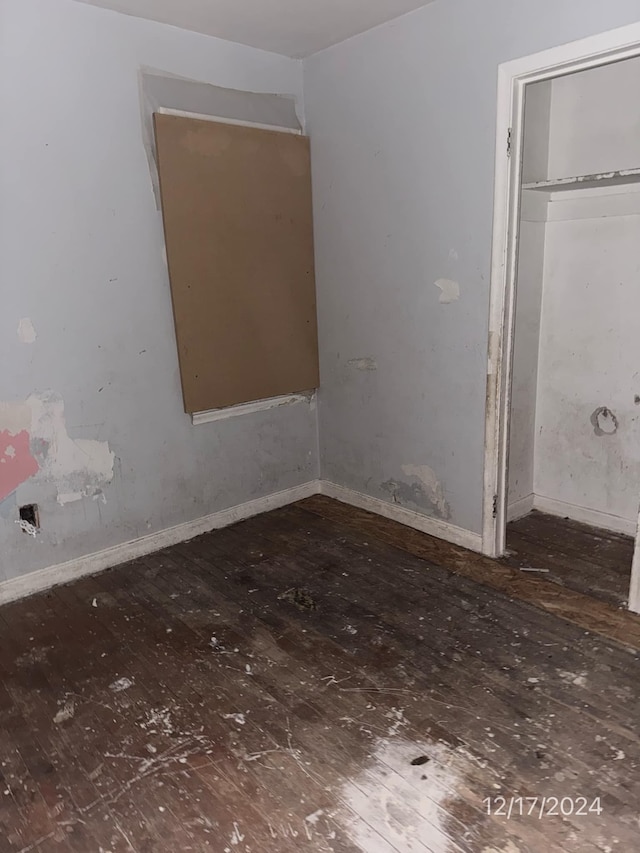 unfurnished bedroom featuring a closet and dark wood-type flooring