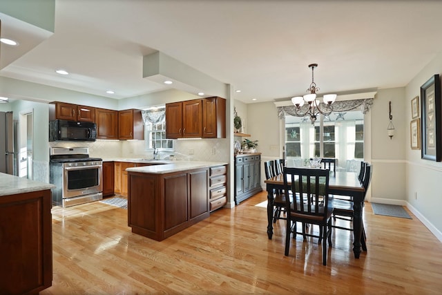 kitchen featuring stainless steel appliances, light hardwood / wood-style flooring, decorative backsplash, and decorative light fixtures