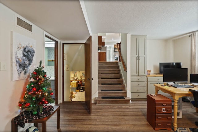 home office featuring dark wood-type flooring, a textured ceiling, and a wall of windows