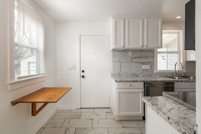 kitchen with tasteful backsplash, plenty of natural light, and white cabinets