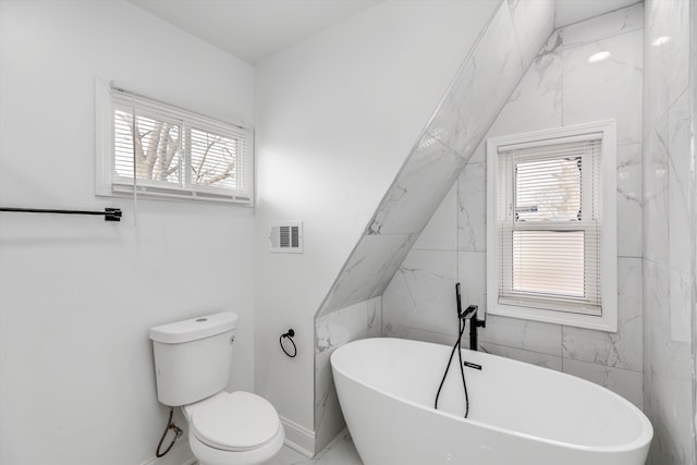 bathroom featuring toilet and a tub