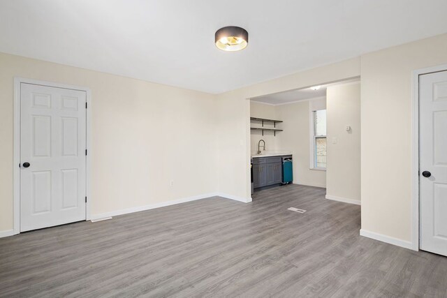 unfurnished living room with light wood-type flooring and sink