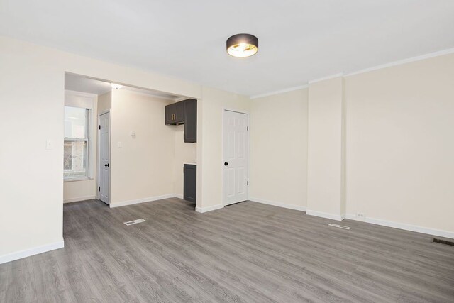 spare room featuring hardwood / wood-style floors and ornamental molding