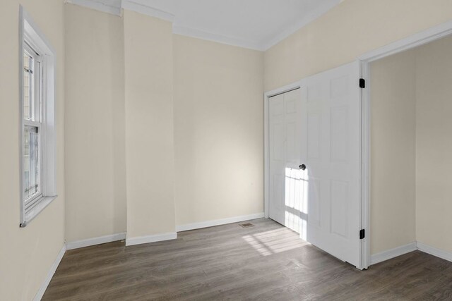 spare room featuring crown molding and dark wood-type flooring