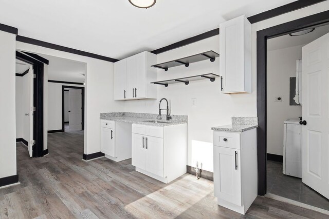 kitchen featuring white cabinets, hardwood / wood-style flooring, and sink