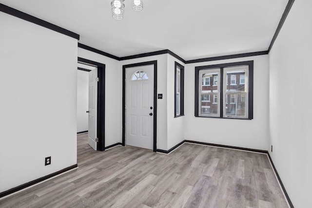 entryway with ornamental molding and light wood-type flooring