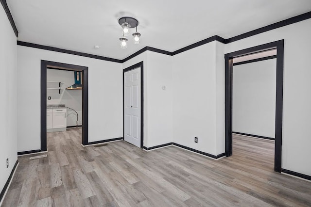 unfurnished room featuring light hardwood / wood-style floors and ornamental molding