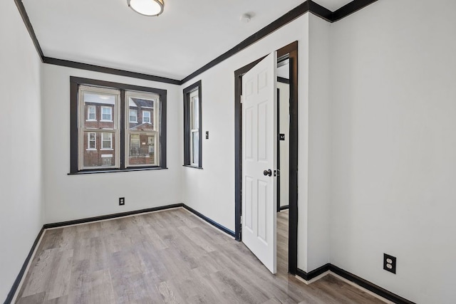 empty room featuring light hardwood / wood-style floors and ornamental molding